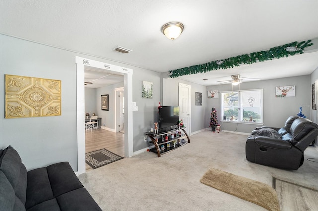 carpeted living room with ceiling fan