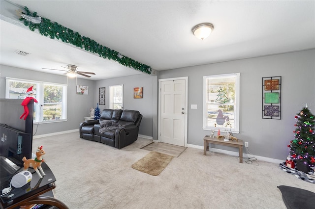 carpeted living room with ceiling fan