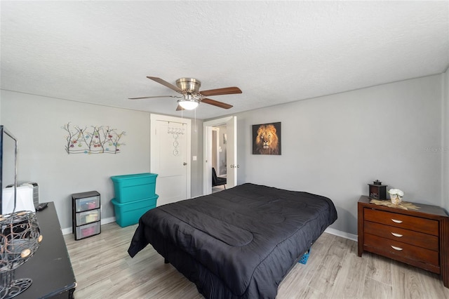 bedroom featuring ceiling fan, light wood-type flooring, and a textured ceiling