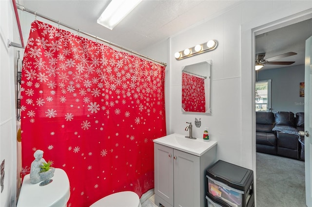 bathroom with a shower with shower curtain, vanity, toilet, and ceiling fan