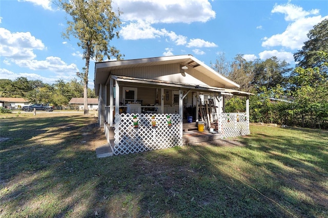 rear view of house featuring a yard