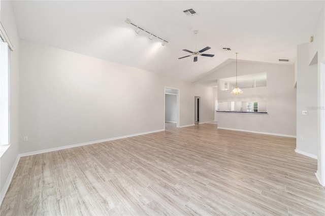 unfurnished living room featuring track lighting, ceiling fan, light wood-type flooring, and vaulted ceiling