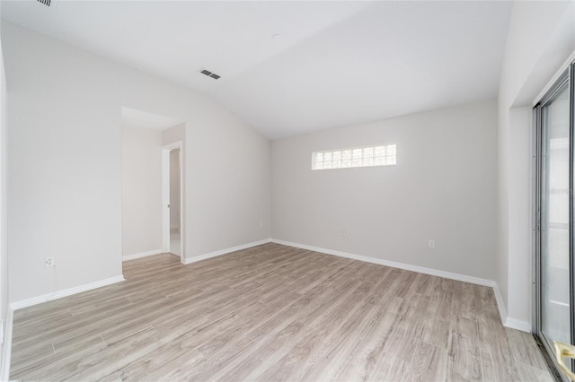 unfurnished room featuring plenty of natural light, lofted ceiling, and light hardwood / wood-style flooring