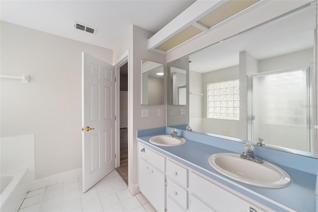 bathroom featuring tile patterned floors, vanity, and shower with separate bathtub