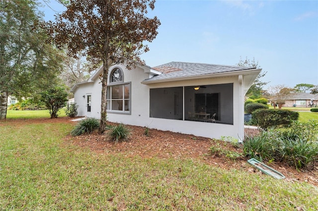 rear view of property featuring a lawn and a sunroom