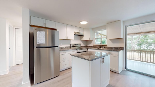 kitchen featuring dark stone countertops, white cabinetry, a center island, and appliances with stainless steel finishes