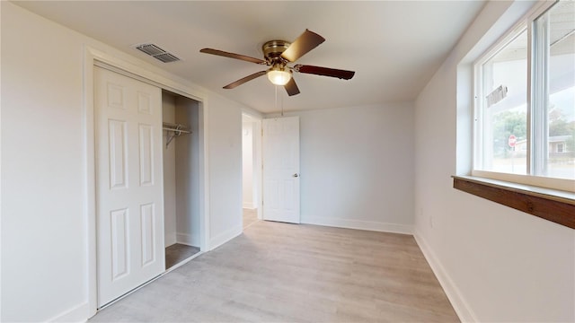 unfurnished bedroom with a closet, light hardwood / wood-style flooring, and ceiling fan