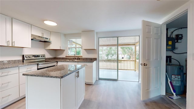 kitchen featuring white cabinets, a kitchen island, stainless steel electric range oven, and electric water heater