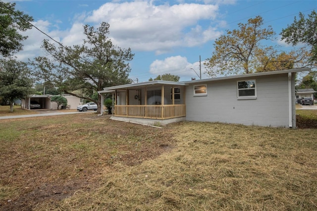 back of house with a lawn and covered porch