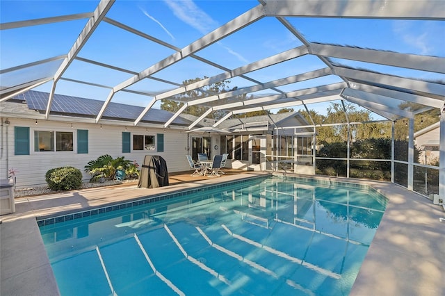 view of swimming pool featuring a patio and glass enclosure