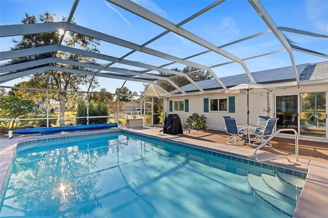 view of pool with glass enclosure and a patio area