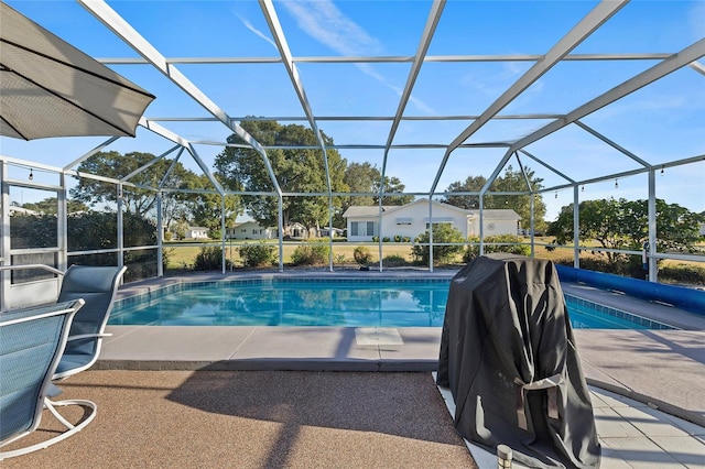 view of swimming pool featuring glass enclosure, a patio area, and a grill