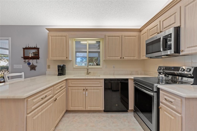 kitchen featuring light brown cabinetry, kitchen peninsula, sink, and appliances with stainless steel finishes