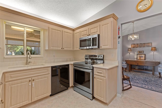 kitchen with lofted ceiling, sink, light tile patterned floors, a textured ceiling, and appliances with stainless steel finishes