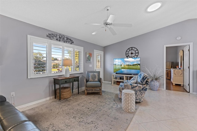 tiled living room featuring ceiling fan and vaulted ceiling