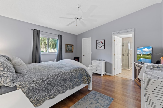 bedroom with ceiling fan, ensuite bathroom, lofted ceiling, and hardwood / wood-style flooring