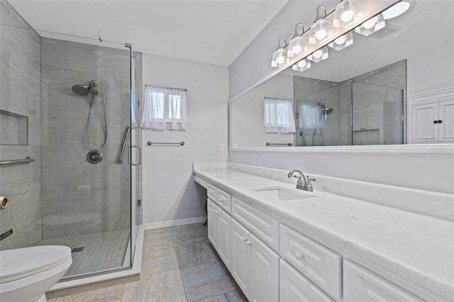 bathroom featuring vanity, toilet, and a shower with door