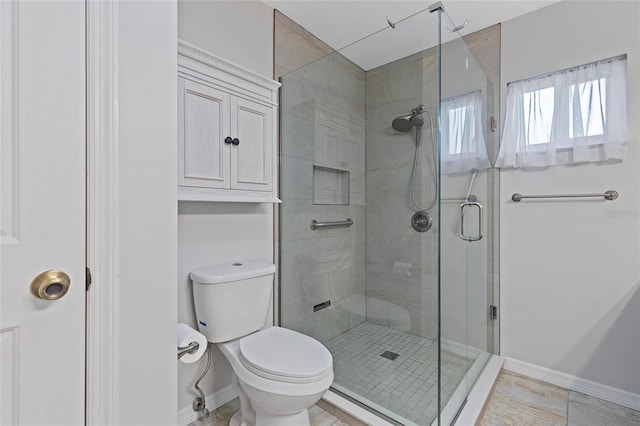 bathroom with a shower with door and toilet