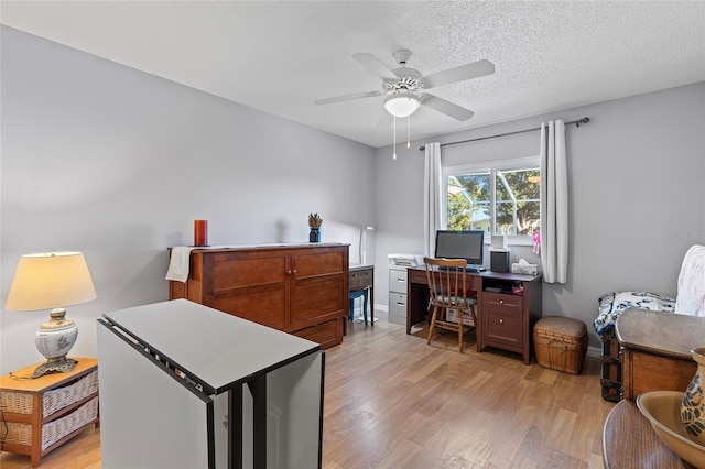 office area with ceiling fan, a textured ceiling, and light wood-type flooring