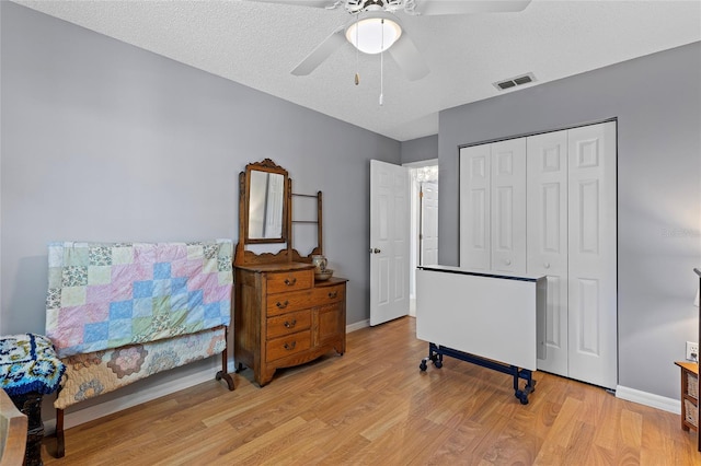 interior space featuring a textured ceiling, a closet, light hardwood / wood-style floors, and ceiling fan