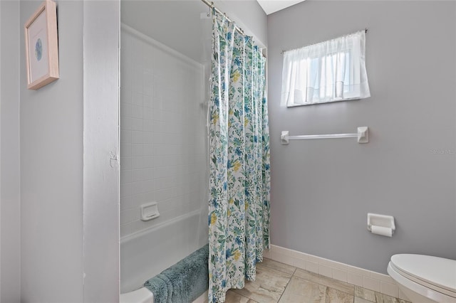 bathroom featuring tile patterned flooring, toilet, and shower / bathtub combination with curtain