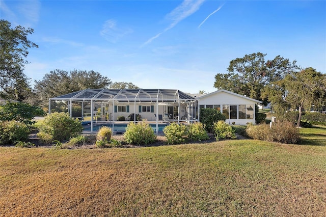 back of house featuring a lawn and glass enclosure