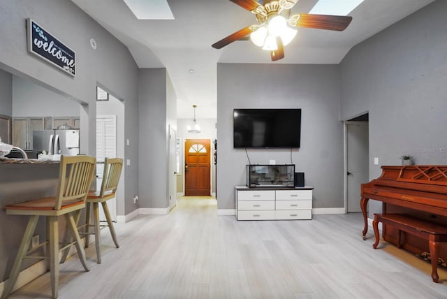 living room with light hardwood / wood-style flooring, ceiling fan, and lofted ceiling