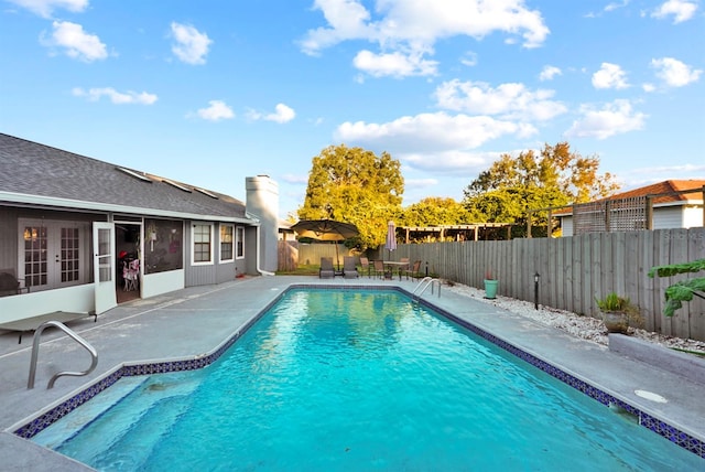 view of swimming pool featuring a patio, french doors, a fenced backyard, and a fenced in pool
