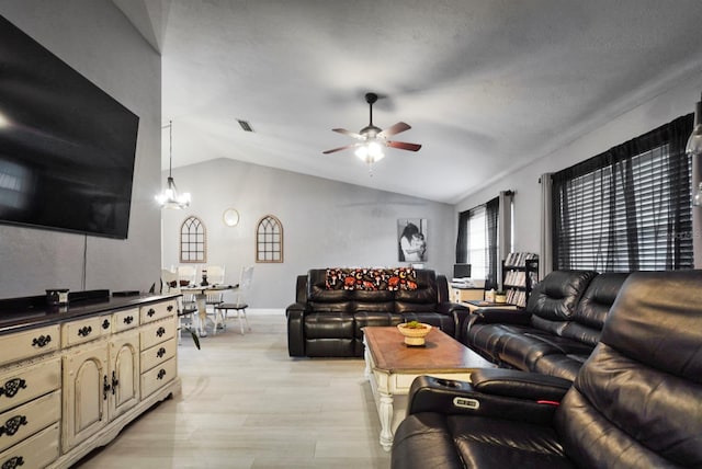 living room with lofted ceiling, light wood-style flooring, visible vents, and ceiling fan with notable chandelier