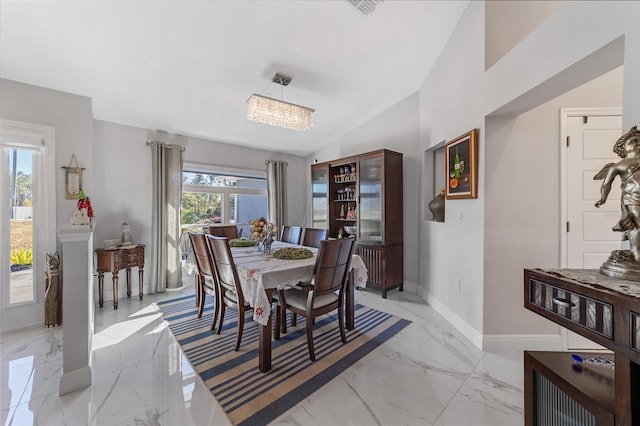 dining room with plenty of natural light, vaulted ceiling, and an inviting chandelier