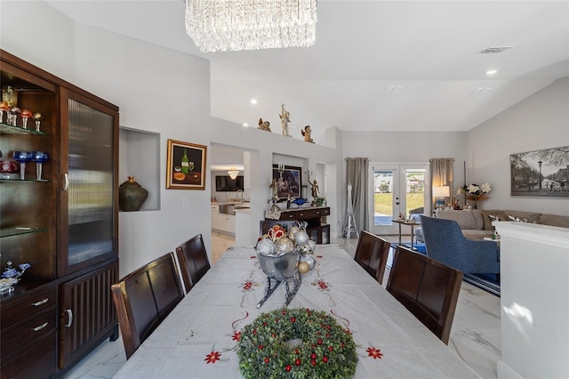 dining room featuring vaulted ceiling, an inviting chandelier, and french doors