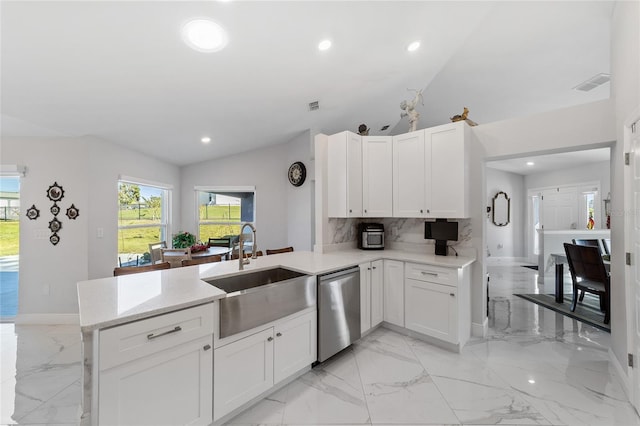 kitchen with kitchen peninsula, stainless steel dishwasher, sink, white cabinets, and lofted ceiling