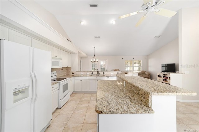 kitchen with a center island, lofted ceiling, white appliances, white cabinets, and sink