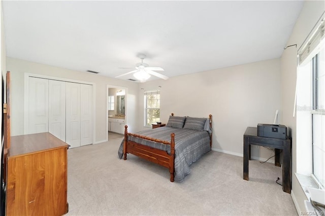 bedroom with light carpet, connected bathroom, a closet, and ceiling fan