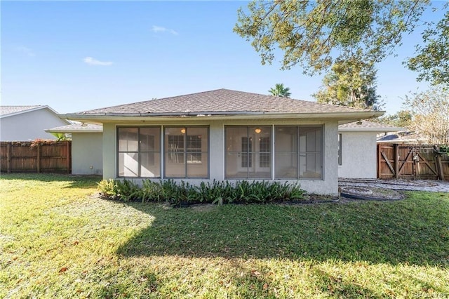 back of property featuring a sunroom and a yard