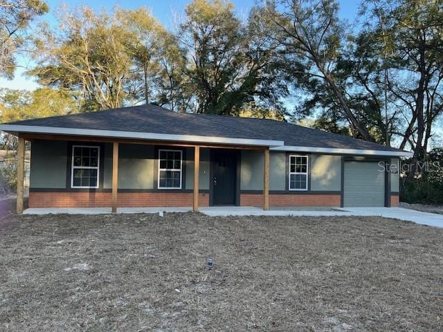 single story home featuring a garage and a porch