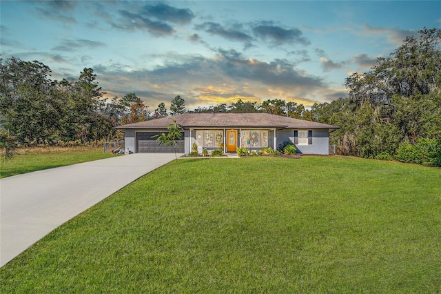 ranch-style home featuring a yard and a garage