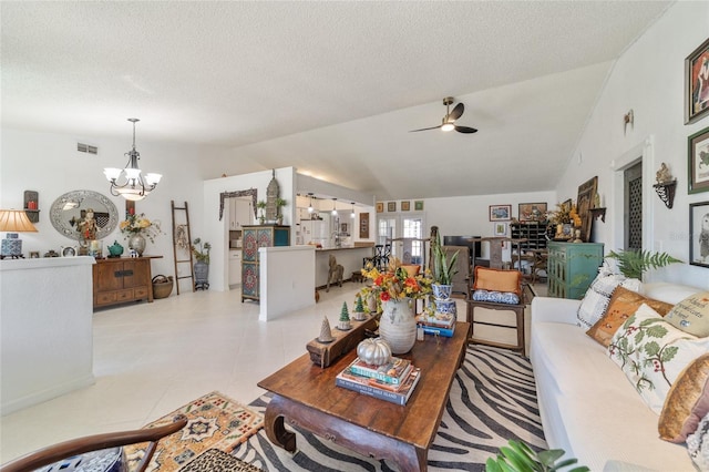 tiled living room featuring ceiling fan with notable chandelier, a textured ceiling, and vaulted ceiling