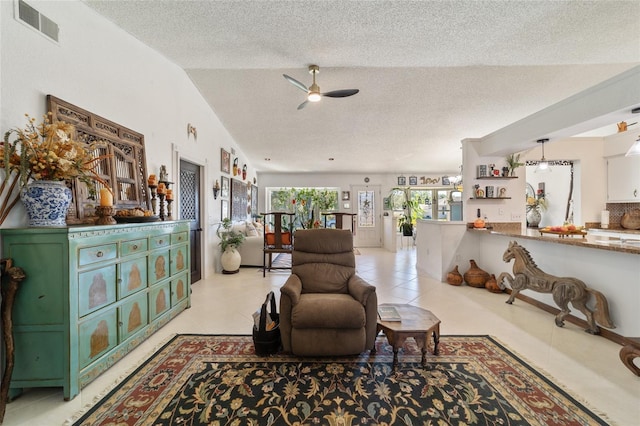 tiled living room with a textured ceiling, vaulted ceiling, and ceiling fan