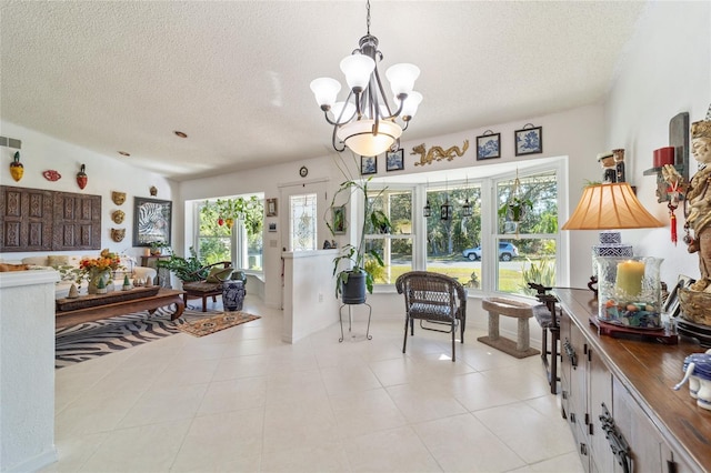 sitting room featuring light tile patterned floors, a textured ceiling, and a notable chandelier