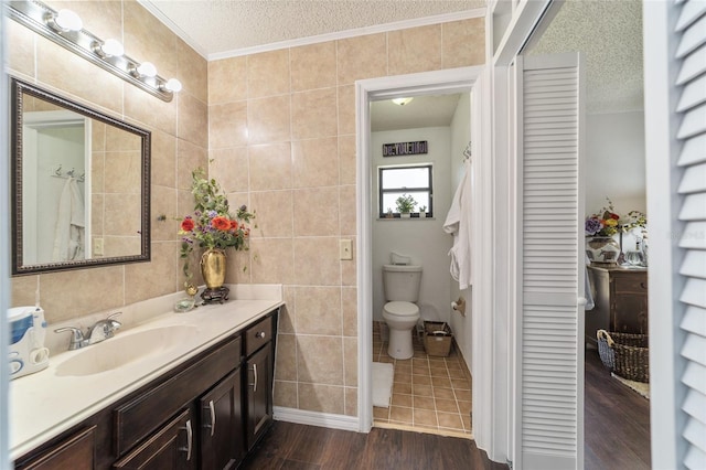 bathroom with hardwood / wood-style floors, toilet, a textured ceiling, and tile walls