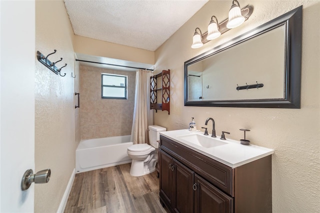 full bathroom featuring shower / bath combo, vanity, a textured ceiling, hardwood / wood-style flooring, and toilet