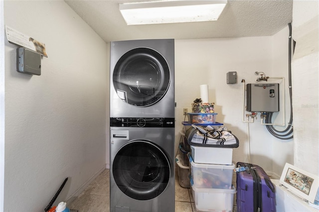 clothes washing area featuring light tile patterned floors and stacked washer and clothes dryer