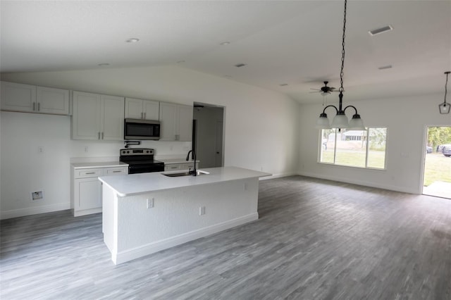 kitchen featuring sink, stainless steel appliances, pendant lighting, lofted ceiling, and a center island with sink