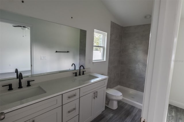 bathroom with vanity, lofted ceiling, hardwood / wood-style flooring, ceiling fan, and toilet