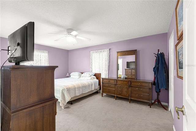 carpeted bedroom with ceiling fan and a textured ceiling