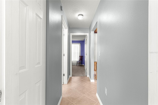 corridor with light tile patterned floors and a textured ceiling