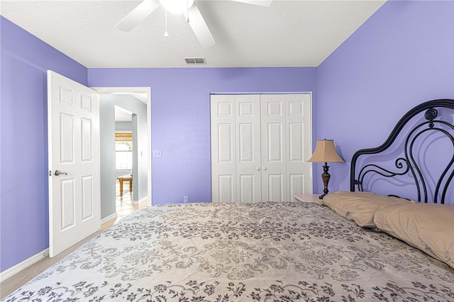 bedroom with carpet flooring, a textured ceiling, a closet, and ceiling fan