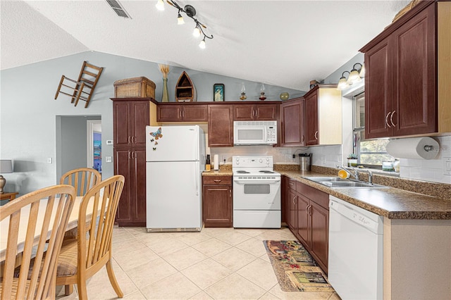 kitchen featuring a textured ceiling, white appliances, vaulted ceiling, and sink