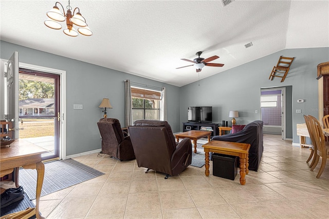 tiled living room featuring ceiling fan with notable chandelier, lofted ceiling, a textured ceiling, and a wealth of natural light